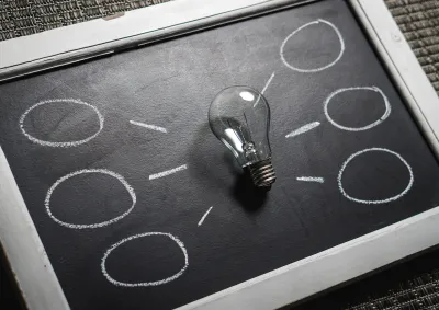 Lightbulb with radiating chalk options representing different choices