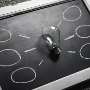 Lightbulb with radiating chalk options representing different choices